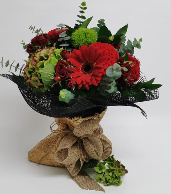 flower bouquet in brown bag with red and green tones